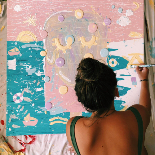 Artist painting a colorful abstract piece on a large canvas, symbolizing creative lead magnet ideas for artists.