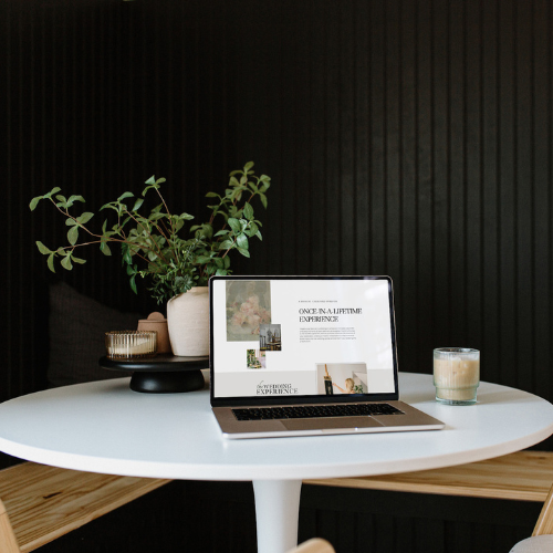 Laptop displaying a professional interior design website, created in a day, on a stylish table with plants and a coffee